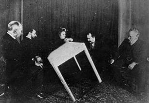 circa 1900: A table apparently moves of its own accord during a seance in Paris. (