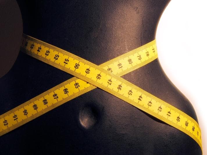 Mannequin with measuring tape wrapped around it