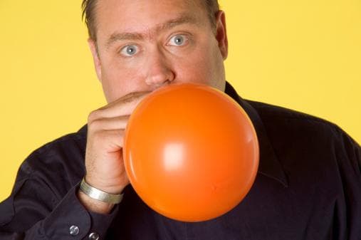 Person holding a balloon to their mouth